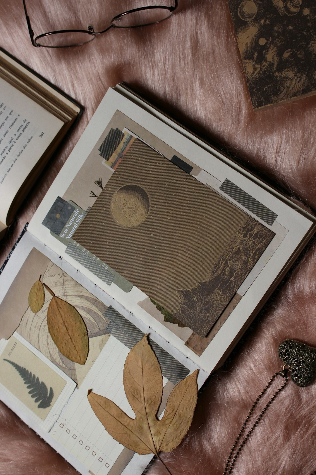 Old magazines and archive photographs spread on a wooden table with a magnifying glass
